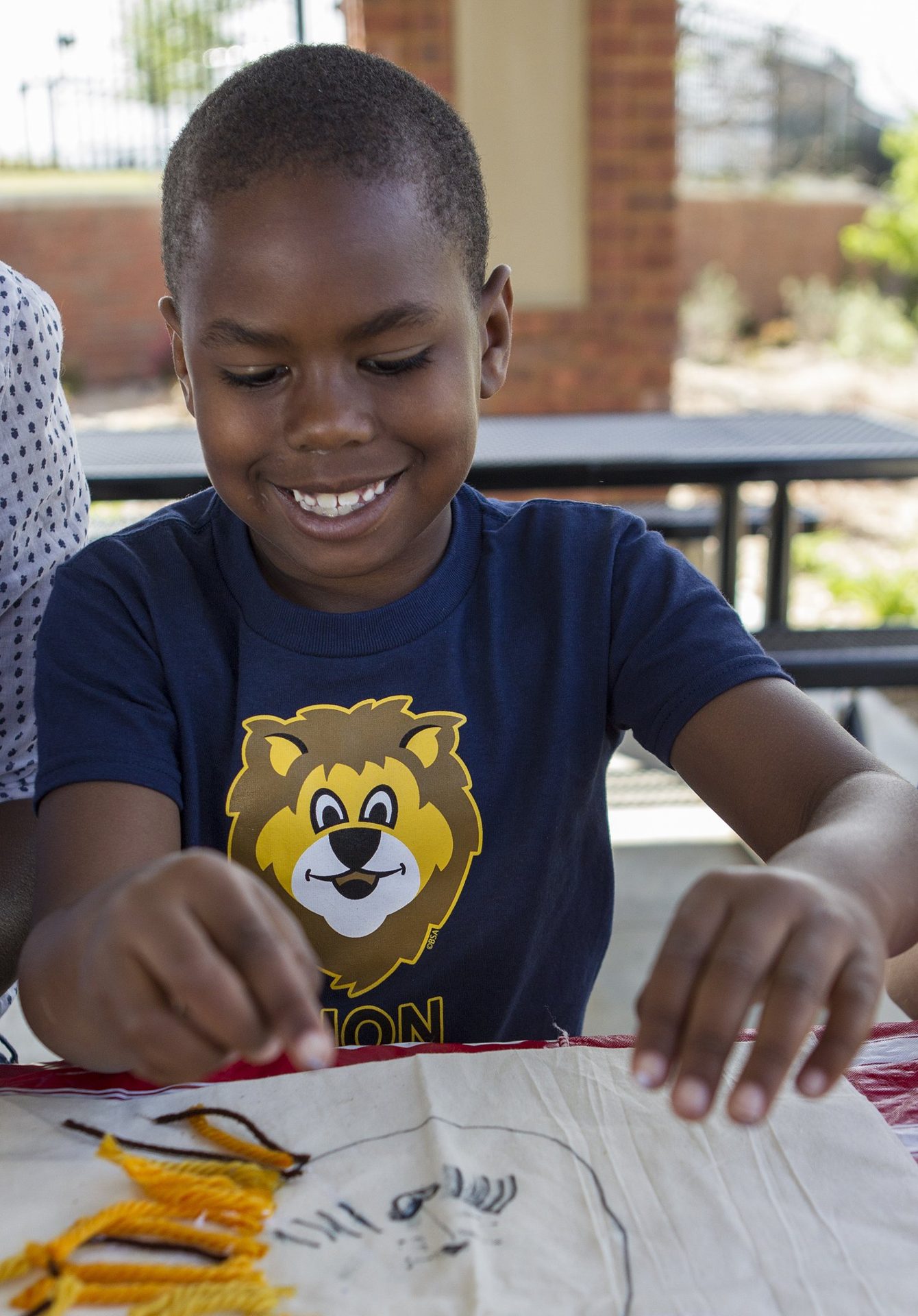 A Lion Cub Scout working on a craft